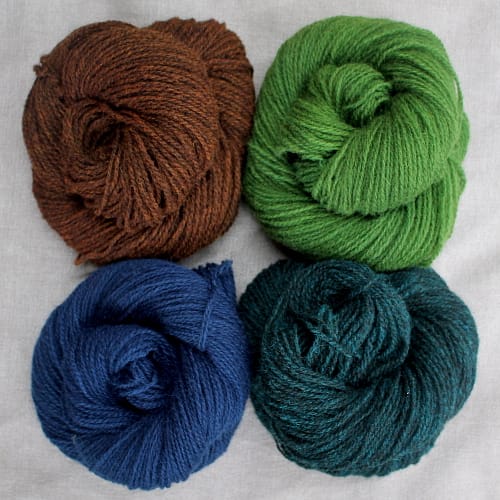 A group of 4 skeins in rich brown, navy blue, teal, and green