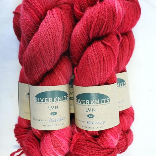 Pile of skeins of bright pinky-red yarn