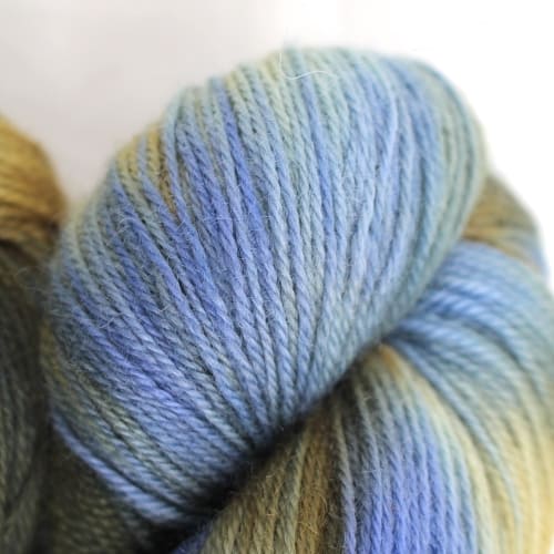 A pile of skeins in sky blue, white, and sandy brown