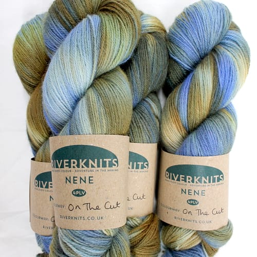 A pile of skeins in sky blue, white, and sandy brown