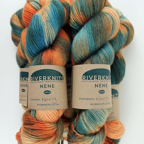 A pile of skeins in orange, blues, and browny greens
