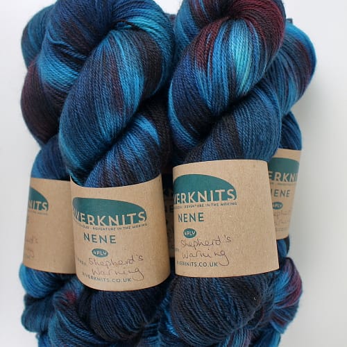 Skeins dyed in variegated dark blues with a hint of burgundy red
